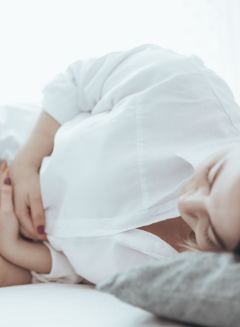 A woman clutching her stomach in pain